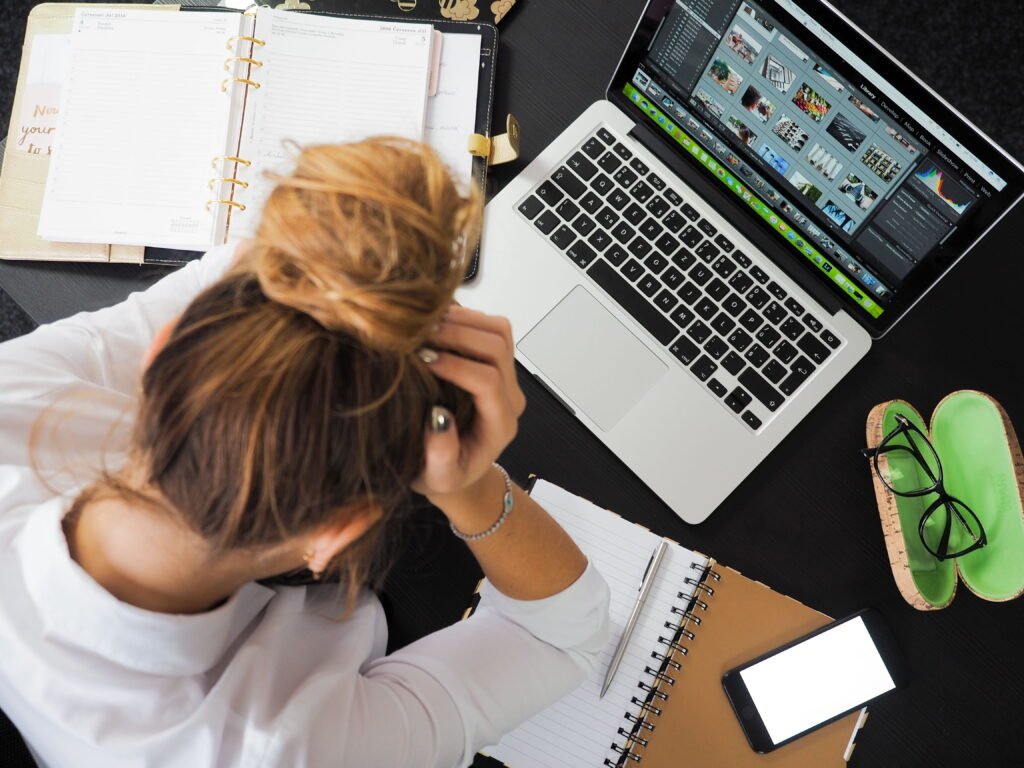 Woman frustrated in front of the computer doing creative work.